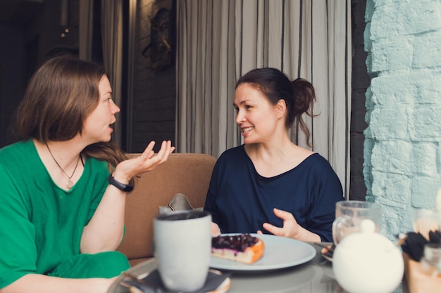 Due donne che parlano e bevono caffè al bar