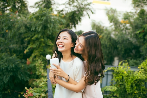 Due donne che si rilassano sul giardino sul tetto bevendo caffè