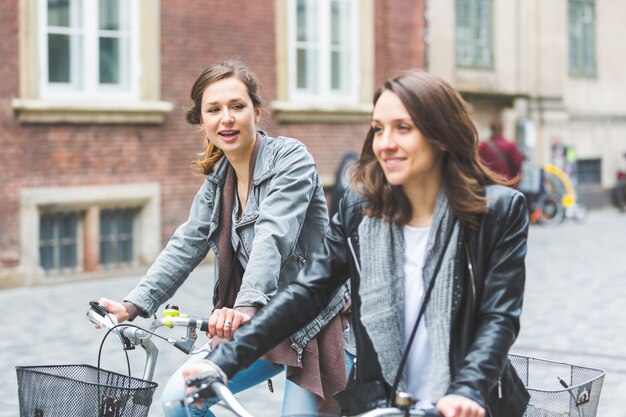 Due donne che vanno in bicicletta a Copenaghen.