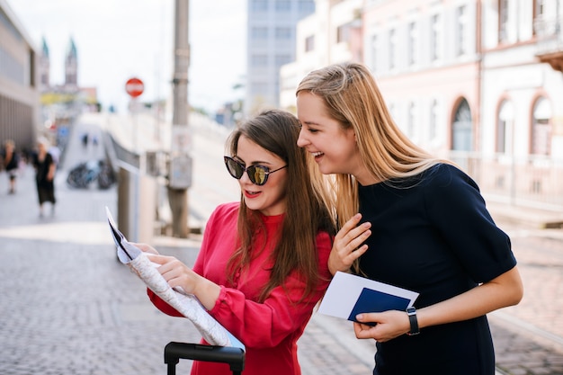 Due donne che viaggiano guardando la mappa