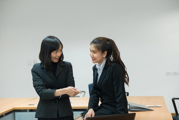 Due donne d'affari seriamente intenzionate a lavorare in ufficio Discutere del progetto di lavoro Persone thailandesi