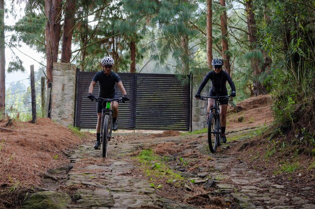 Due donne in bicicletta lungo un sentiero di montagna