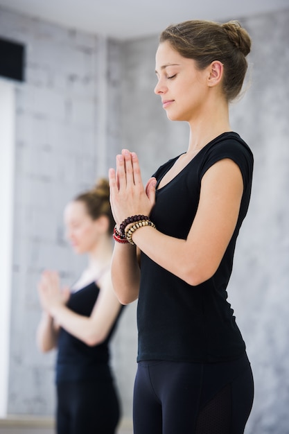 Due donne in palestra, esercizio di rilassamento o lezione di yoga