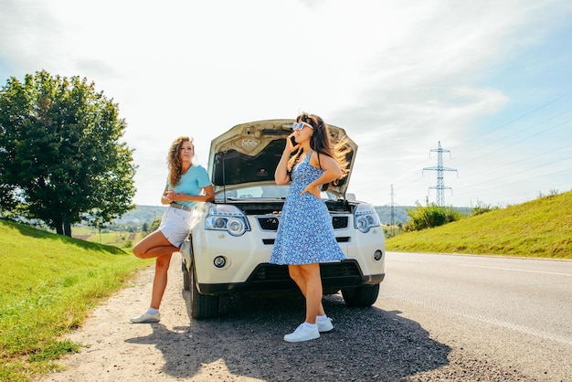 Due donne in strada chiamano il servizio auto. macchina rotta. viaggio in macchina