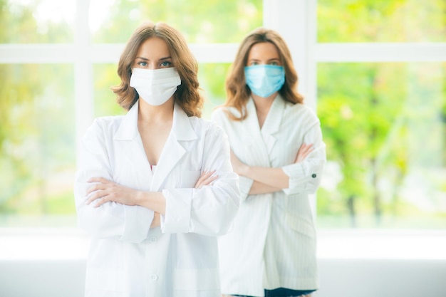 Due donne in tute mediche protettive e maschere per il viso