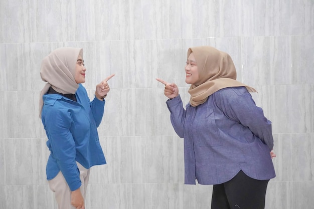 Due donne indonesiane asiatiche che indossano hijab indossano abiti blu chiaro e blu scuro