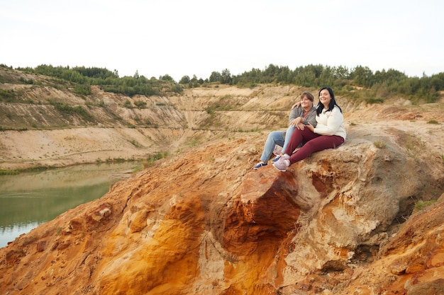 Due donne sedute sulla collina e godersi la vista del bellissimo lago all'aperto