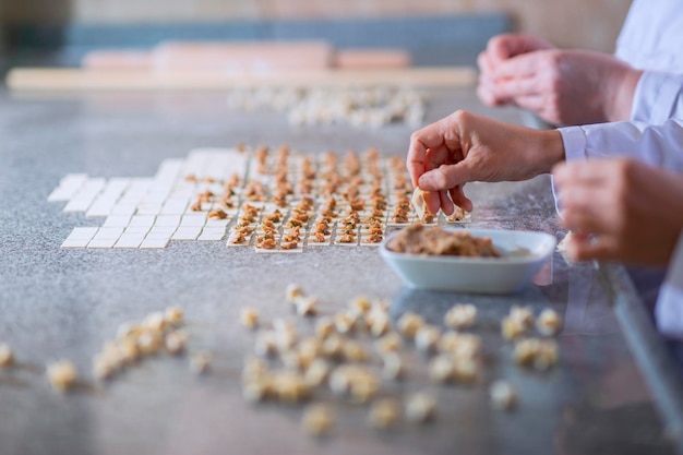 Due donne stanno preparando i ravioli turchi con polpette e pasta