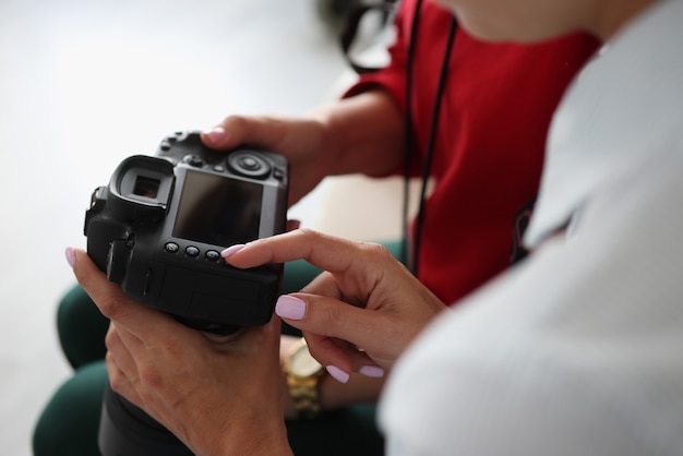 Due donne tengono la macchina fotografica nelle loro mani