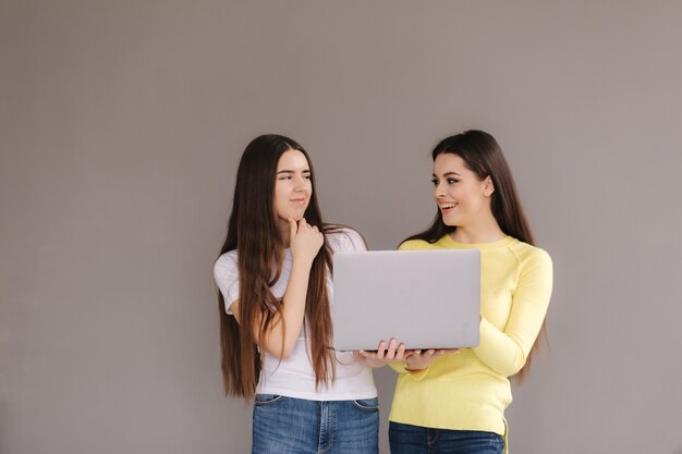 Due donne tengono un laptop. le donne si guardano