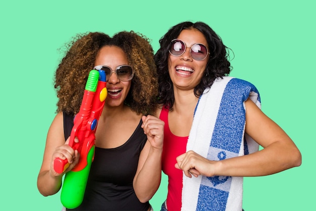 Due donne una con i capelli afro e l'altra latina sono pronte per una vacanza al mare in costume da bagno