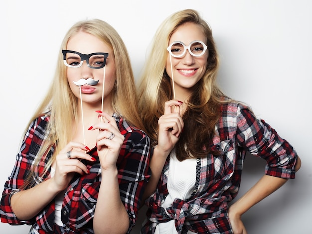 Due eleganti ragazze hipster sexy migliori amiche pronte per la festa, su sfondo grigio