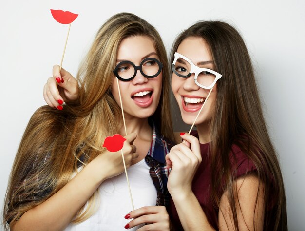 Due eleganti ragazze hipster sexy migliori amiche pronte per la festa, su sfondo grigio