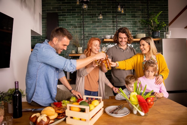 Due famiglie brindano con il sidro mentre preparano la cena in cucina