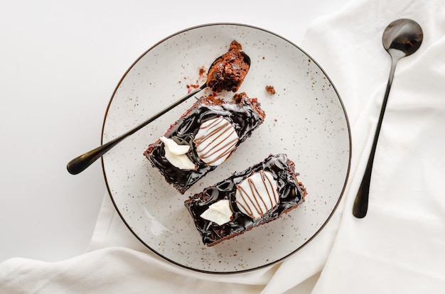 Due fette di torta al cioccolato lustrata sul piatto bianco. Colpo ambientale, spazio della copia