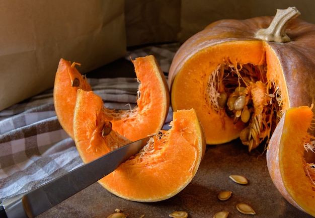 Due fette di zucca, un coltello e un asciugamano da cucina sul bancone