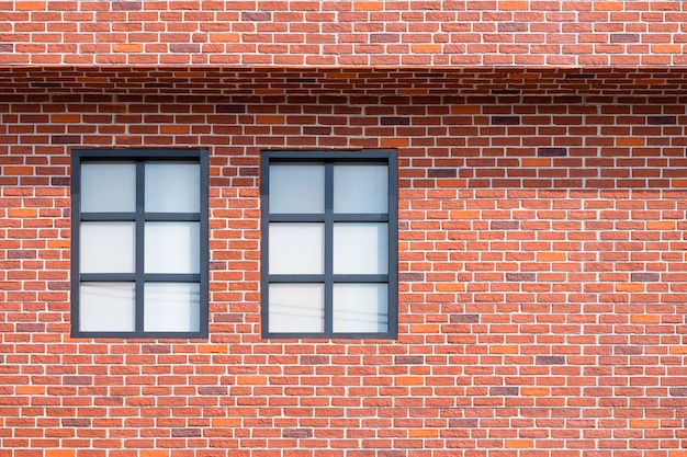 Due finestre di vetro sul muro di mattoni della costruzione di una casa d'epoca