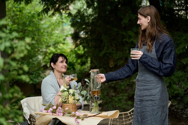 Due fioristi mamma e figlia che bevono tè in giardino