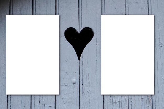 Due fogli di carta bianca per brochure su tavola di legno sfondo grigio cuore in bianco piatto Mock up love