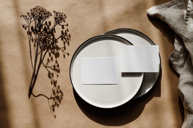 Due fogli di carta bianca su piastre Ceramica minimalista su carta kraft Spazio per la copia del modello aziendale piatto