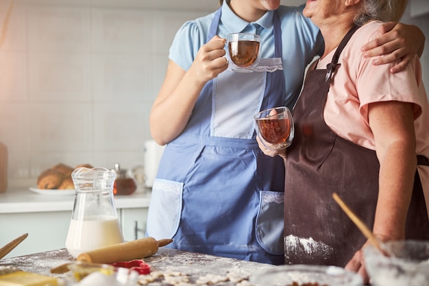 Due fornai che prendono il tè e si abbracciano vicino al tavolo della cucina