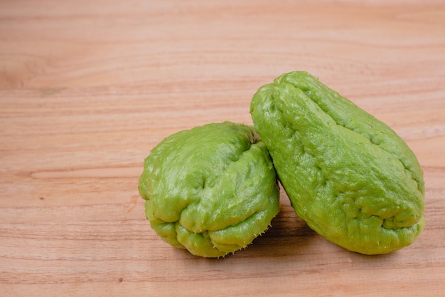 Due frutti di chayote in tavola di legno