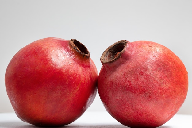 Due frutti di melograno isolati su uno sfondo bianco.