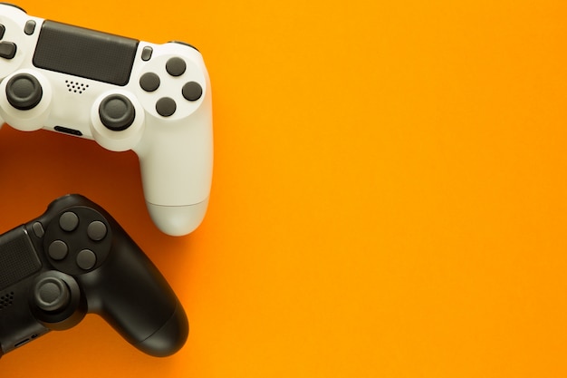 due gamepad su un tavolo giallo e copia spazio