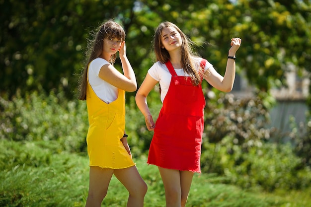 due gemelli adolescenti in un abito scolastico giallo e rosso nel pomeriggio