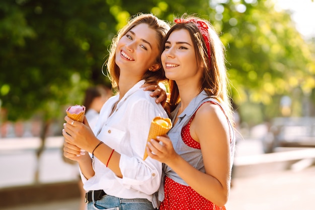 Due giovani amiche divertirsi e mangiare il gelato.