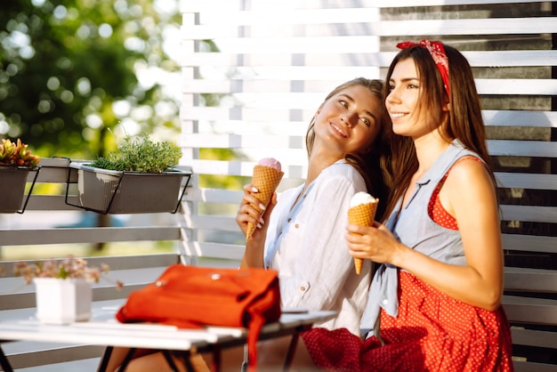 Due giovani amiche divertirsi e mangiare il gelato.