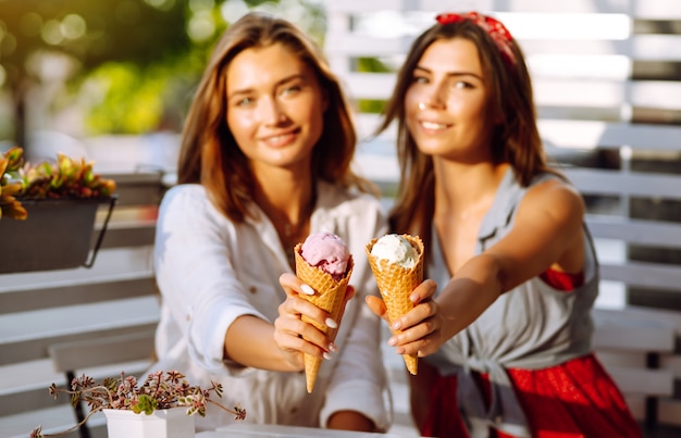 Due giovani amiche divertirsi e mangiare il gelato.