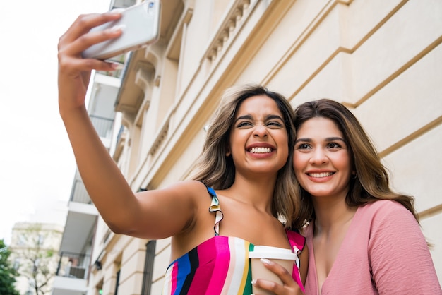 Due giovani amici che si divertono insieme e fanno un selfie con il loro cellulare