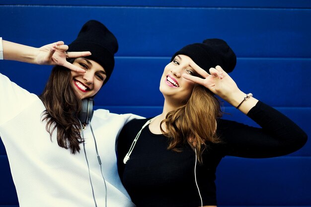 Due giovani amici di ragazza hipster insieme divertendosi all'aperto stile di vita