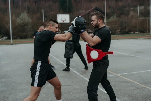 Due giovani atleti di boxe uomini che si allenano all'aperto Training kickboxingTwo maschi che praticano la boxe all'aperto Sparring box di allenamento al di fuori del concetto di sport