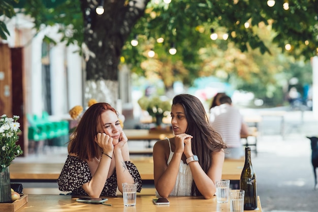 Due giovani belle donne amiche che parlano in un caffè all'aperto