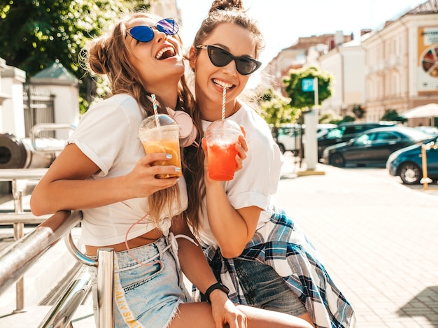 Due giovani belle donne hipster sorridenti in abiti estivi alla moda