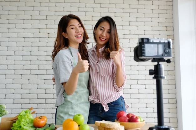 Due giovani blogger asiatici dell&#39;alimento della donna che parlano mentre registrando video, concetto del vlog