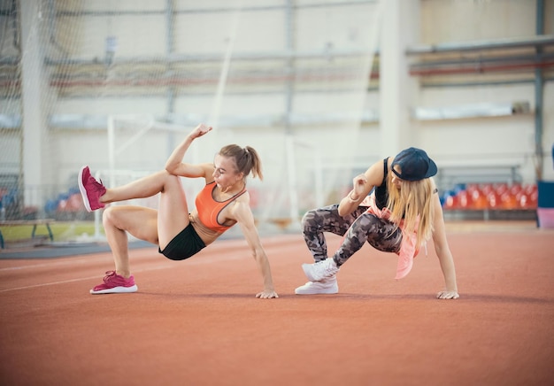 Due giovani donne atletiche che si allenano in modo sincrono fanno movimenti