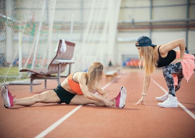 Due giovani donne atletiche che si allungano e si preparano a correre