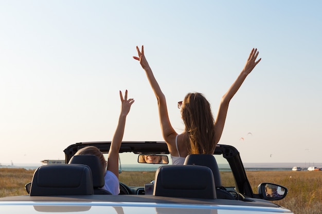 Due giovani donne attraenti in un'automobile del cabriolet