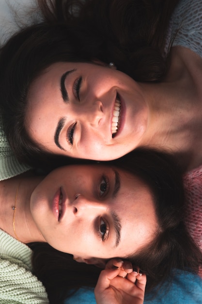 Due giovani donne carine sdraiate su un letto