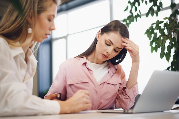 Due giovani donne che lavorano insieme in ufficio