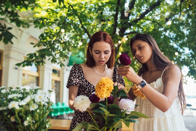 Due giovani donne compongono un bellissimo bouquet festivo