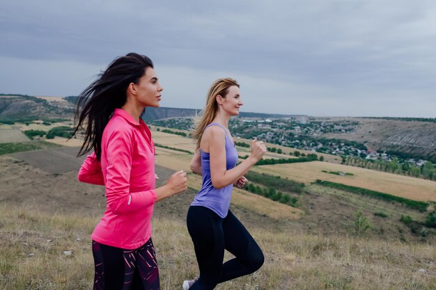 Due giovani donne corridore allenamento nel parco estivo vicino fitness donna jogging all'aperto stanco ragazza jo...