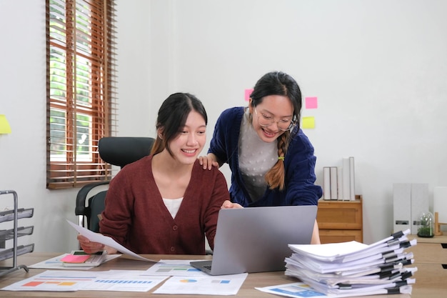 Due giovani donne d'affari asiatiche che lavorano insieme nello spazio ufficio