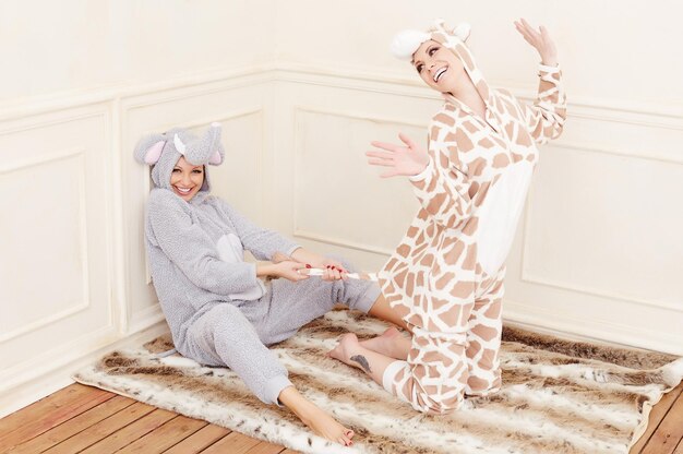 Due giovani donne in pigiama che si divertono.