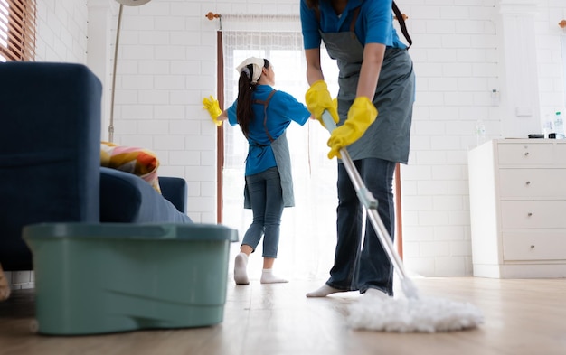 Due giovani donne in uniforme stanno pulendo il soggiorno a casa