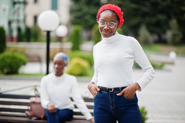 Due giovani donne musulmane africane attraenti moderne alla moda alte e magre in hijab o sciarpa a turbante poste insieme