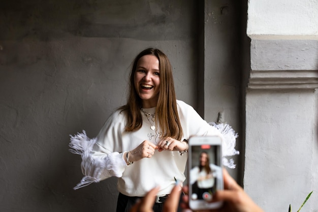 Due giovani donne si scattano foto e video su uno smartphone su una terrazza